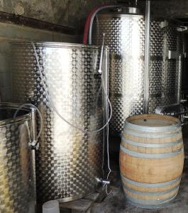 a wine barrel sitting next to two metal tanks at Domaine Houillon in Faucon