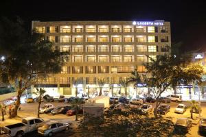a large building with cars parked in a parking lot at Lacosta Hotel in Aqaba