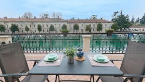 a table and chairs on the balcony of a building at Fiori sull'Acqua Apartments in Peschiera del Garda