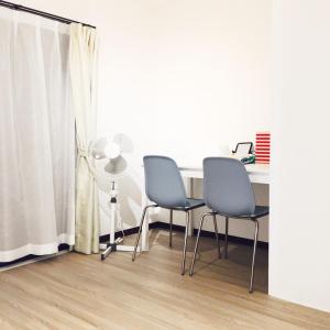 Pokój z 2 krzesłami, stołem i wentylatorem w obiekcie Guest House Fukuoka W302 w mieście Kasugabaru
