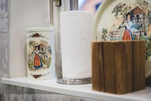 two cups and a roll of toilet paper on a shelf at Hissla Riquewihr in Riquewihr +12 photos