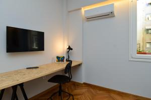 a room with a desk and a tv on a wall at Athens heart, Syntagma metro studio in Athens