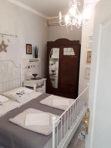a white bedroom with a bed and a chandelier at House Grabic in Tivat