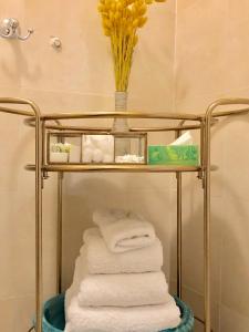 einen Handtuchhalter mit Handtüchern und eine Vase gelber Blumen in der Unterkunft Décor Canal House in Amsterdam
