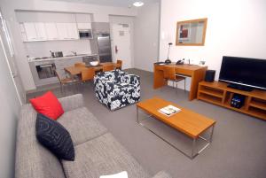 a living room with a couch and a flat screen tv at Gladstone Downtown Central Apartment Hotel Official in Gladstone