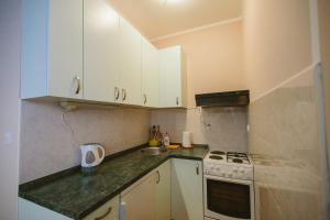 a kitchen with white cabinets and a stove top oven at Studio apartman Salopek in Ogulin