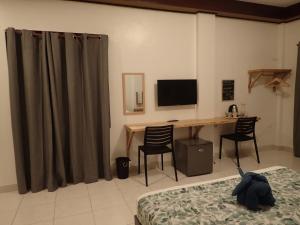a bedroom with a desk with a computer and a bed at La Sirenita in Panglao Island
