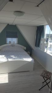 um quarto com uma cama grande e uma janela em B&B Beemsterlust em Westbeemster