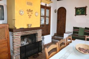 a living room with a fireplace and a table and chairs at Casa Huerta San Francisco in Casarabonela