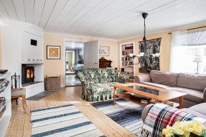 ein Wohnzimmer mit einem Sofa und einem Tisch in der Unterkunft Ängsö Fishermans Cottage in Västerås