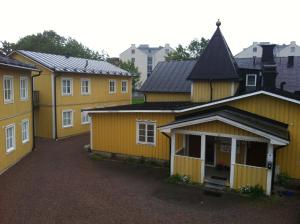 una fila de casas amarillas con entrada en Uppsala Lägenhetshotell en Uppsala