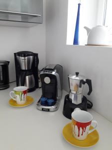 a kitchen counter with two cups and a coffee maker at Stadtoase Koblenz in Koblenz