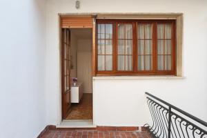 een open deur van een wit gebouw met een bank bij Lupori House in Viareggio