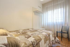 a bedroom with a bed and a chair and a window at Lupori House in Viareggio