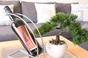 a bottle of wine and a small pine tree on a table at Appartement Scharf in Bad Harzburg