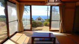 a living room with a large window and a table at Shirahama Ocean Villa in Shirahama