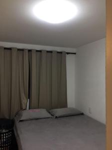 1 dormitorio con 1 cama y una luz en el techo en Apartamento Cabo Branco, en João Pessoa