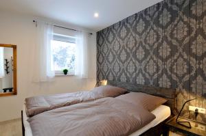 een slaapkamer met een bed en een muur met een raam bij Villa Kiesel in Zempin