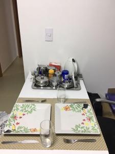 una mesa con dos platos y vasos. en Apartamento Cabo Branco, en João Pessoa