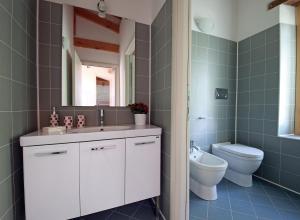 ein Badezimmer mit einem WC, einem Waschbecken und einem Spiegel in der Unterkunft Agriturismo la Scala in Salò