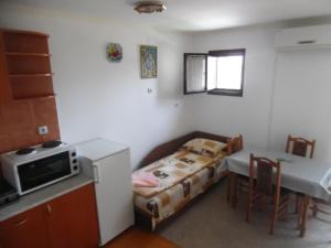 a small room with a bed and a table and a microwave at Apartments Selena & Doroteja in Soko Banja