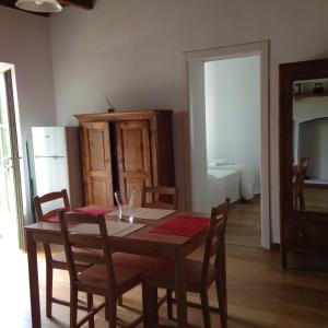 a dining room with a table and chairs and a bedroom at Appartamento La Camelia in Ameno