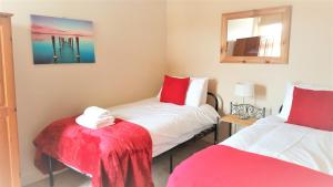 a small room with two beds and a mirror at Swindon City Centre Duplex - EnterCloud9SA in Swindon