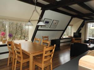 a dining room and living room with a wooden table and chairs at Ardennen Vakantie Chalet in Durbuy