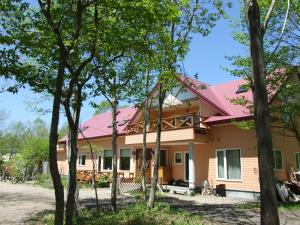 a house with a pink roof and some trees at Forestlodge Subaru in Teshikaga