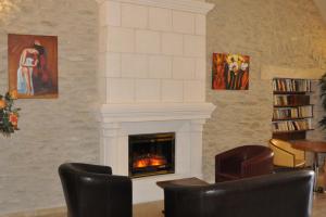 a fireplace in a living room with two chairs at Hôtellerie Notre Dame de Lumières in Goult