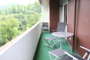 a room with a table and chairs on a balcony at Appartement Scharf in Bad Harzburg