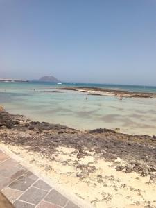 コラレホにあるCenter Corralejo Beachの水泳する人々のいる海岸