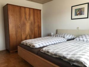 Limbach的住宿－Ferienwohnung Link，一间卧室设有两张床和木制橱柜