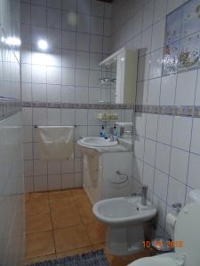 a white tiled bathroom with a sink and a toilet at Casa da Baía in Prainha de Baixo +29 photos