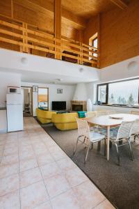 a kitchen and living room with a table and chairs at Panoramic Apartments - MontePalazzo Sinaia in Sinaia