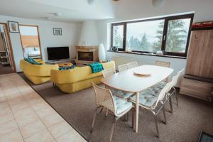 ein Wohnzimmer mit einem Tisch und einem Sofa in der Unterkunft Panoramic Apartments - MontePalazzo Sinaia in Sinaia