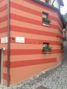 a building with red and white stripes on it at Castagna Holiday Home in Nesso