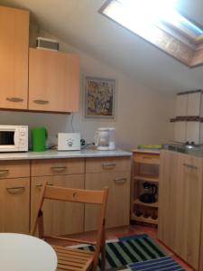 a kitchen with wooden cabinets and a white microwave at Ferienwohnung Lindenstraße in Lübeck