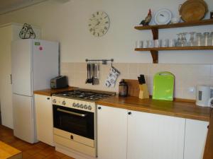a kitchen with a stove and a white refrigerator at 'La Maison Catalpa' French Farmhouse with Pool & Jaccuzi in Saint-Privat-des-Prés