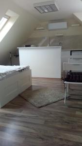 エゲルにあるMiNa apartmanの白い部屋(ベッド1台、テーブル付)