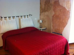 una camera con un letto rosso e una coperta rossa di B&B Vicolo Vecchio a Terracina