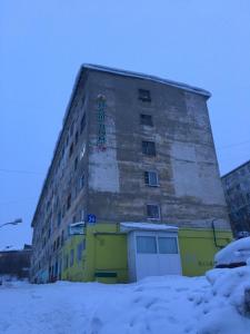 a tall building in the snow in front at Apartment Vash Dom Vecher in Murmansk