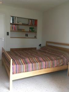 - une chambre avec un lit et une couette à rayures dans l'établissement Villa Magali, à Sanary-sur-Mer