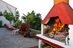 a brick oven with a fire inside of it at Apartments Maestro in Stomorska