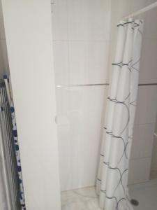 a shower with a white shower curtain in a bathroom at Alfaqueque Apartment in Seville