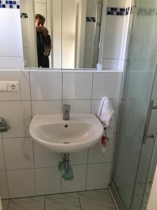 Ein Mann fotografiert ein Waschbecken im Badezimmer. in der Unterkunft Gästezimmer am Oos Bach in Baden-Baden