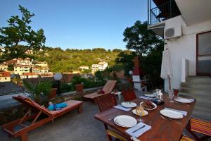 einen Holztisch und Stühle auf einer Terrasse mit Aussicht in der Unterkunft Apartments Maestro in Stomorska