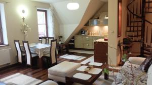 Una sala de estar con una mesa y una cocina. en Apartament Parkowa Polana, en Polanica-Zdrój