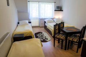 ロビにあるMagadorのベッド3台、テーブル、椅子が備わる客室です。
