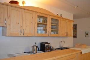 a kitchen with wooden cabinets and a counter top at Agritur All'Olivo in Sover